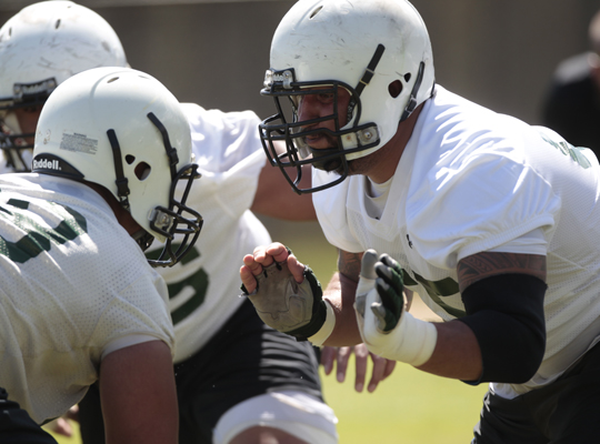 Offensive lineman Kody Afusia, right, during the first day of football camp on Aug. 4. /><figcaption class=