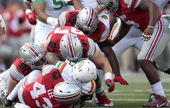 Hawaii running back Paul Harris was pounced on by Ohio State linebacker Darron Lee, bottom, defensive lineman Tommy Schutt, left, defensive lineman Joey Bosa, 97, and defensive lineman Tyquan Lewis in the first half Saturday.