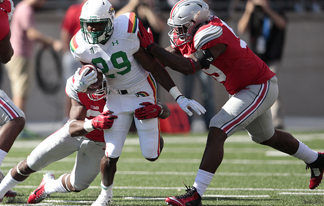 Hawaii running back Paul Harris was brought down by Ohio State safety Tyvis Powell, left, and defensive lineman Tyquan Lewis in the first half.
