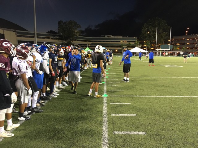 Former UH defensive backs Richard Torres (in blue, on the left) and Leonard Peters (on the field) helping to run the DB drills. 