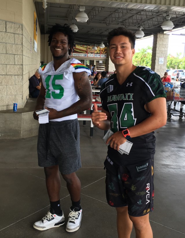 Daniel Lewis and slotback Nic Tom passed out schedule cards and helped Costco shoppers carry goods on Saturday.
