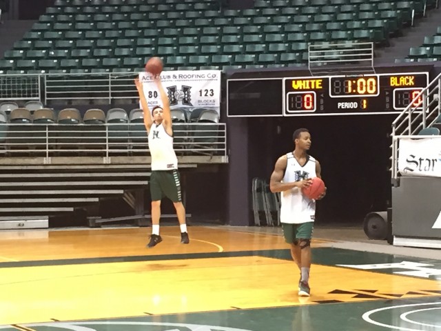 Brian Garrett got up a jump shot while Larry Lewis Jr. rebounded during UH practice in the Stan Sheriff Center on Monday.